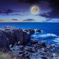 Sea Ã¢â¬â¹Ã¢â¬â¹wave breaks about boulders at night Royalty Free Stock Photo